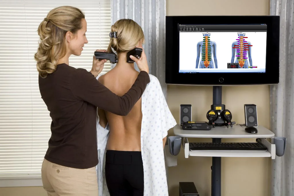 Clinician performing a MyoVision ScanVision sEMG scan on a patient's upper back